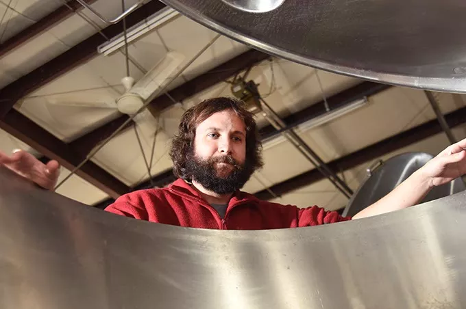 Jonathan Stapleton part owner of 405 Brewing Company in Norman, looks into one of the large stainless steel brewing vesels. mh