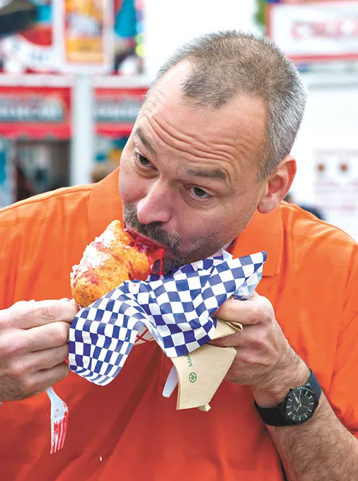 Paul Boyd takes a bite of a gooey fried large gummy bear. (Shannon Cornman)