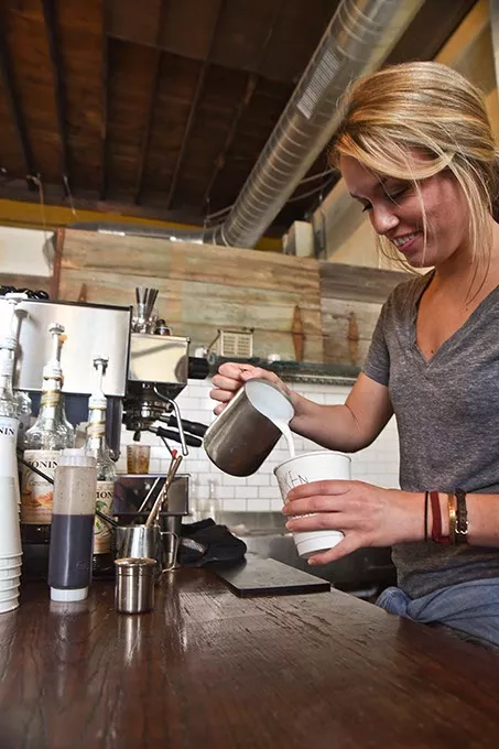 Barista Savannah Crockett makes a latte recently at the Hoboken Coffee Roasters in Guthrie. mh