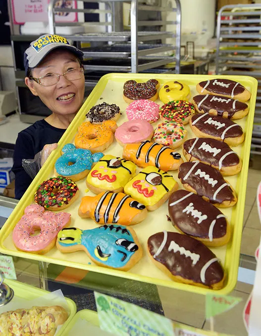 Sarah Lee shows a tray of donuts at Daylight Donuts, Friday, Nov. 18, 2016. - GARETT FISBECK