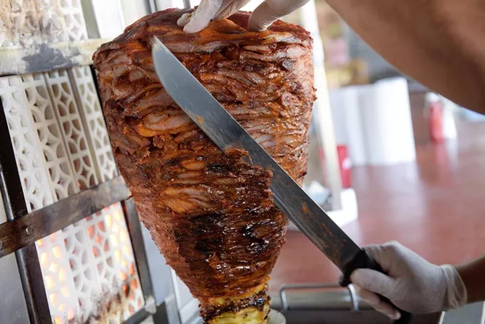 El Fogoncito partner and head cook Abisaid Samaniego cuts a trompo of pork. | Photo Garett Fisbeck