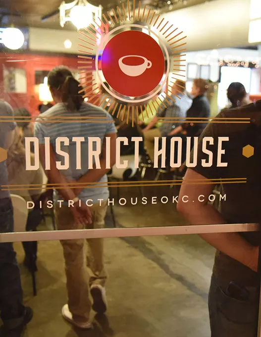 A crowd through the glass for Parker Cunningham, at District House in the Plaza District, where he performed songs while his mother author Sarah Cunningham did a reading and book signing event, 1-27-15. mh