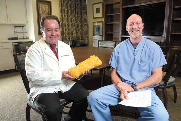 Dr. J. Arden Blough and Chiropractor Todd Farris pose for a photo at Broadway Clinic in Oklahoma City, Monday, Jan. 16, 2016.  Dr. Blough holds a prop representing five pounds of body fat. - GARETT FISBECK