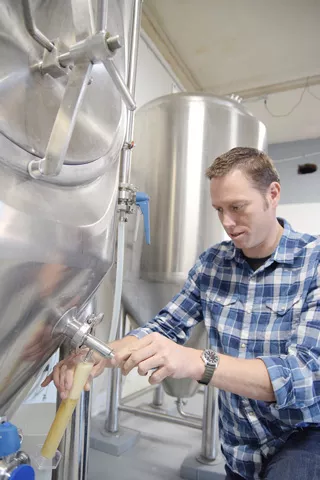 Brewmaster Stephen Basey draws some beer for testing at Lazy Circles Brewing. (Photo Mark Hancock)