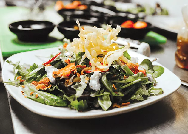 The Guyutes salad tops mixed greens with strawberries, goat cheese, chopped bacon and fried wonton strips along with its infused honey dressing. - ALEXA ACE