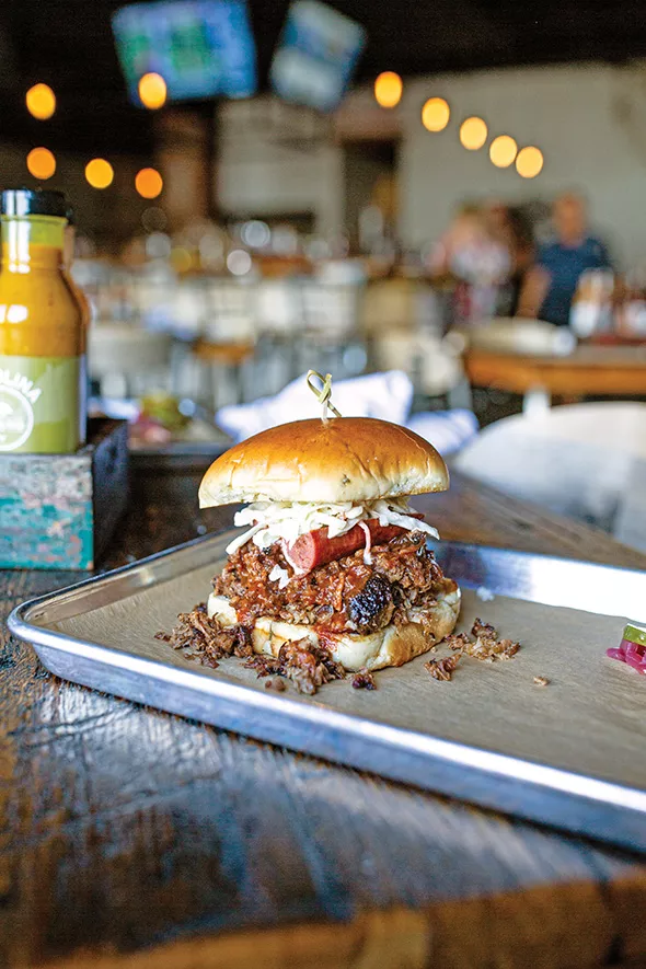 The Full Boar sandwich is piled high with pulled pork, brisket, a hot link and coleslaw. - ALEXA ACE