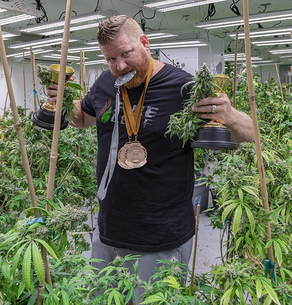 Tyler Doolittle poses with Fire Leaf's Cannabis Cup prizes. - PHILLIP DANNER