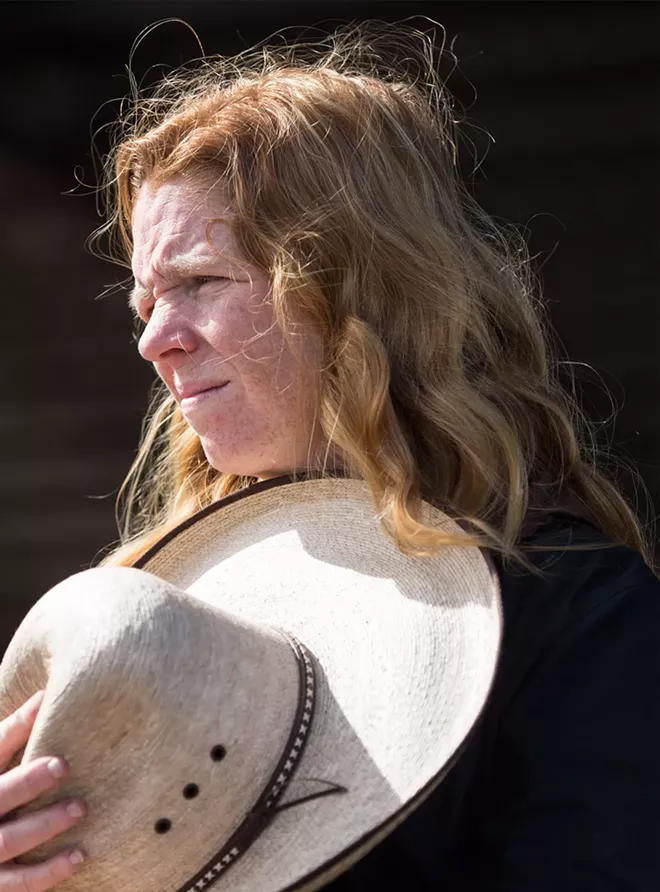 Along with hundreds of other riders, Donna Compton, of Youngsville, North Carolina, removes her hat during “The Star Spangled Banner” at the end of the drive.