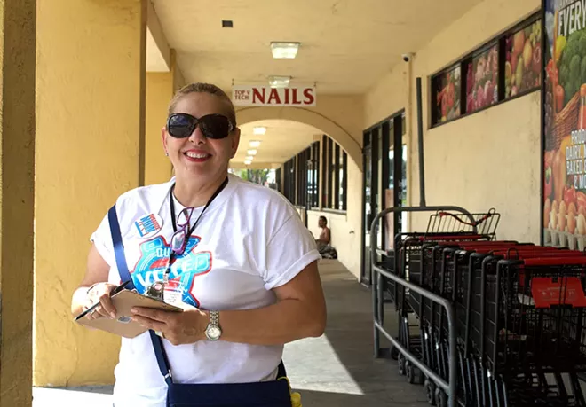 Maria Merced Valiente waits at Bravo Supermarket to register voters. - PHOTO BY MONIVETTE CORDEIRO