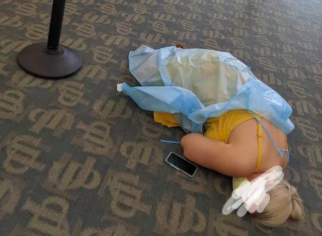 A photo of a woman lying on the floor while waiting for COVID-19 antibody treatment has gone viral. - PHOTO VIA REDDIT