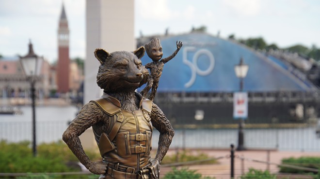 Rocket and Groot Fab 50 statue at Epcot with the 50th-anniversary logo seen on a Harmonious barge LED screen behind them. - IMAGE VIA BIORECONSTRUCT | TWITTER