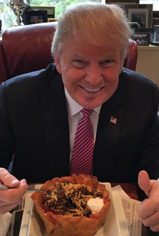 Trump eating a taco bowl from Trump Towers.