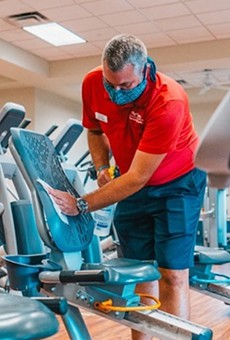 A worker in the Villages cleans exercise equipment on June 1