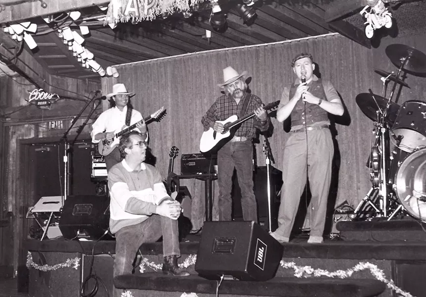 J. David Sloan (center) and The Rogues perform with Irisn entertainer Charlie McGettigan (right) during a St. Patrick's in the mid-'80s. Then-KNIX on-air personality W. Steven Martin is seated onstage. - COURTESY OF W. STEVEN MARTIN