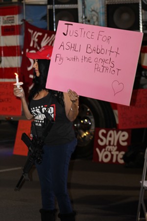 One participant at a vigil in Phoenix on January 6 holds a sign to remember fellow protestor Ashli Babbitt, a 35-year-old Air Force veteran who was shot and killed by Capitol Police officer Michael Byrd while attempting to breach a barricaded door in the House chamber last year. - ELIAS WEISS