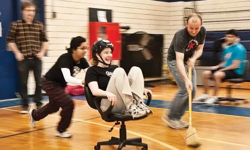 Aruna Balakrishnan, of the team "Ruth and the Ruthless," pushes teammate Ruth Wylie during a Human Curling tournament, at the West Penn Community Center. - JOHN ALTDORFER