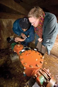 ELDI's Kendall Pelling, right, and maintenance worker Charles Gilbert check a water meter at East Liberty Garden Apartments. - HEATHER MULL