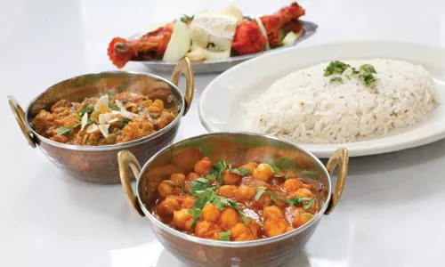 From left, clockwise: Navartan (mixed vegetables), tandoori chicken, spiced rice and aloo cholae (chick peas and potatoes) - HEATHER MULL