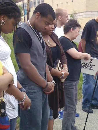 Jordan Miles prays with supporters at a May 14 rally at the Pittsburgh Police headquarters. - PHOTO BY SARA GAUL