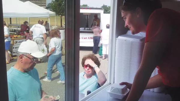 Lynne Szarnicki serves pierogies from the Pierogi Truck at the Green Tree Park farmers' market. - PHOTO BY AMYJO BROWN