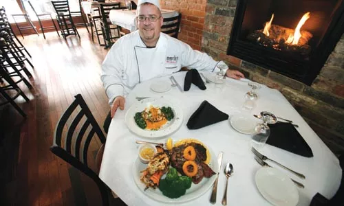 Matt Mantini, with a pair of wood-fired entrees - HEATHER MULL