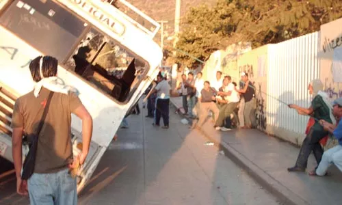 Oaxacans pull a bus on its side to use as a barricade on Oct. 29, the day the federal police entered the city.