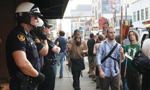 Patrick Young (right) joins the picket in front of Oakland's militray recruiting center, on Forbes Avenue.