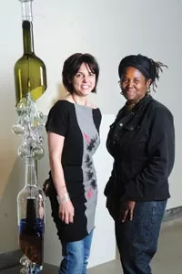 Pittsburgh Glass Center's Community Relations Coordinator Heather Joy Puskarich and GAGI Festival Director Christine Bethea pose with Melissa Fitzgerald's "Rainsong Seeks Water." - HEATHER MULL
