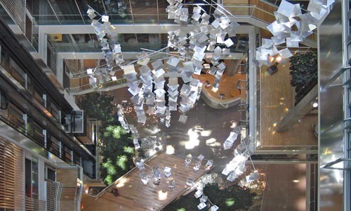 Reflects well: a view from above of the light-dispersing chandeliers in the Genzyme Headquarters, in Boston. Photo courtesy of Behnisch Architekten.