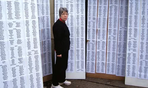 Scilla Wahrhaftig, head of the American Friends Service Committee's state office, with a list of the names of American soldiers killed in the Iraq War, being readied for a vigil marking the 3,000th death. - PHOTO BY PAUL WAHRHAFTIG