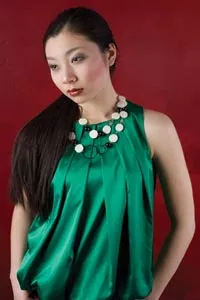 Siran wears: green satin top by Gracia Fashion, available at Jupe Boutique; onyx and African bone necklace by local designer Alma Lleros-Thompson for Alma Jewelry, available at Mia Boutique. - HEATHER MULL