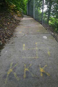 The letters "KKK" spray-painted on a public walkway - HEATHER MULL