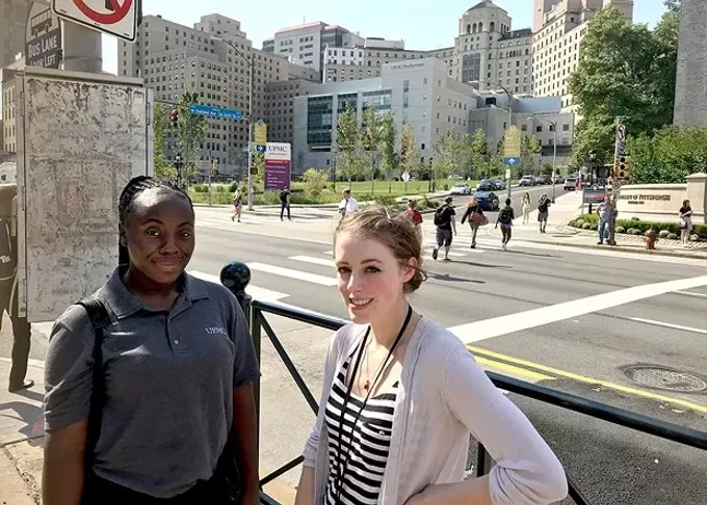 UPMC employees Ashley Smith (left) and Ellie Lalonde (right) in front of UPMC Presbyterian in Oakland - CP PHOTO: RYAN DETO