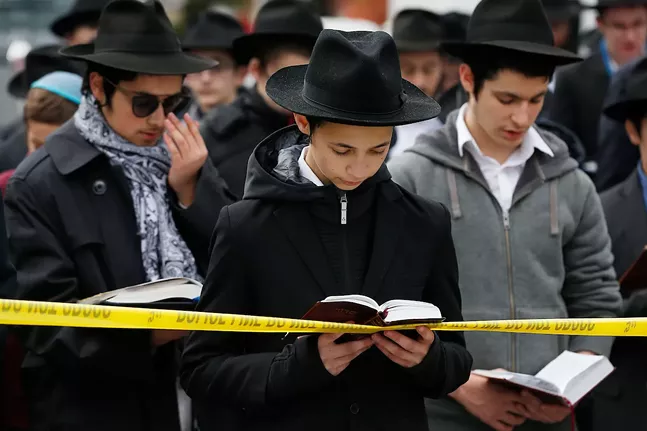 Students from the Yeshiva School join together in prayer in front of the Tree of Life Synagogue on Mon., Oct. 29, 2018. - CP PHOTO: JARED WICKERHAM
