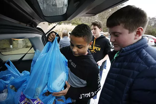 Shadyside Academy eighth grader Maxwell Kimbrough, 13, haps load up food supplies into a car during a 412 Food Rescue - CP PHOTO: JARED WICKERHAM