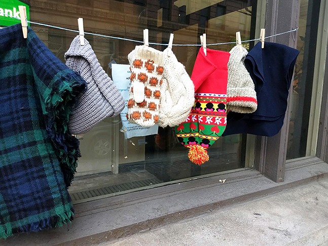 Free hats, gloves, and scarves hang outside the Catholic Charities' Winter Warming Station on Liberty Avenue. - CP PHOTOS: KEVIN SHEPHERD