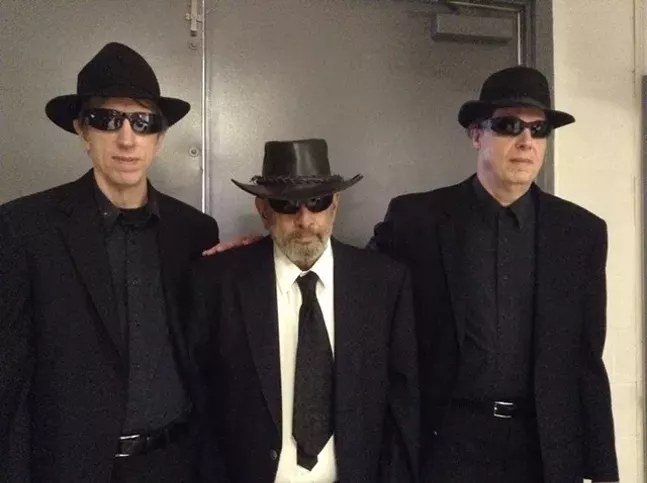 Men in black pictured with Fred Saluga, director of Fayette County Pa. Bigfoot Research Project, at the 10th Annual Butler Paranormal Conference - MICHELE GEORGE