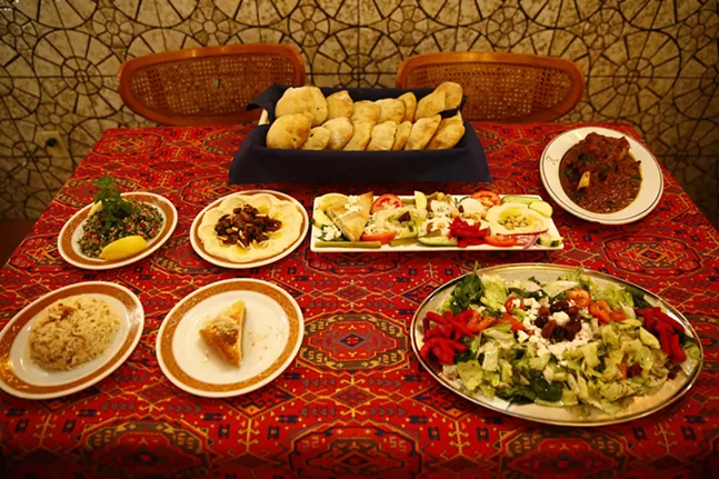 Various dishes including homemade artisan Syrian bread, Tabolli, hummus bi lahme, mazza, mowzat lamb shank, rice, Khalil's signature salad, and desserts - CP PHOTO: JARED WICKERHAM