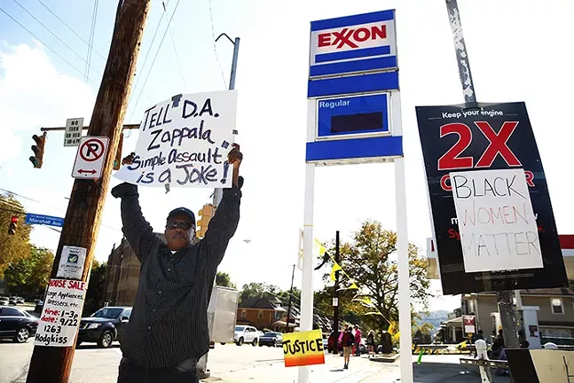 A protester holds up a sign calling out District Attorney Stephen Zappala outside the Exxon gas station in Marshall-Shadeland. - CP PHOTO: JARED WICKERHAM