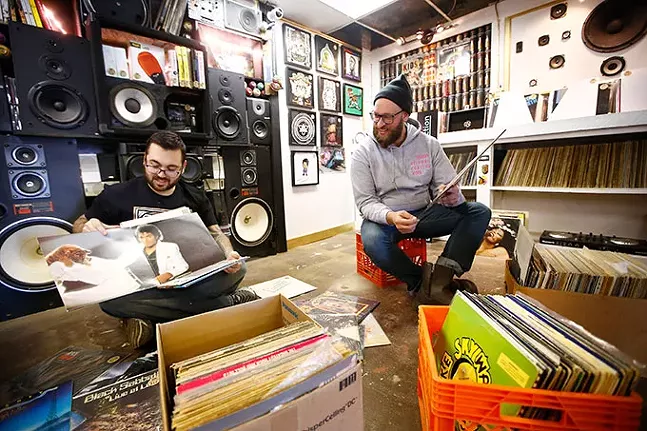 T.J. Harris, owner of The DJ Connection, and Josh Snider, owner of Flower City Printmakers, look through boxes of records inside their Bridgeville location. - CP PHOTO: JARED WICKERHAM