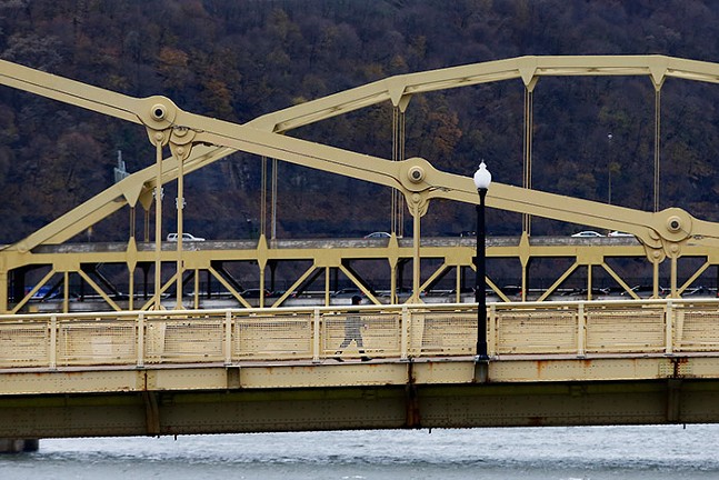 A pedestrian crossing a bridge in Pittsburgh, Pa. - CP PHOTO: JARED WICKERHAM
