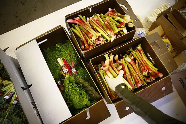 Derek Dumont puts together farm-share boxes at Harvie Farms Pittsburgh in Lawrenceville on Mon., May 11, 2020. - CP PHOTO: JARED WICKERHAM