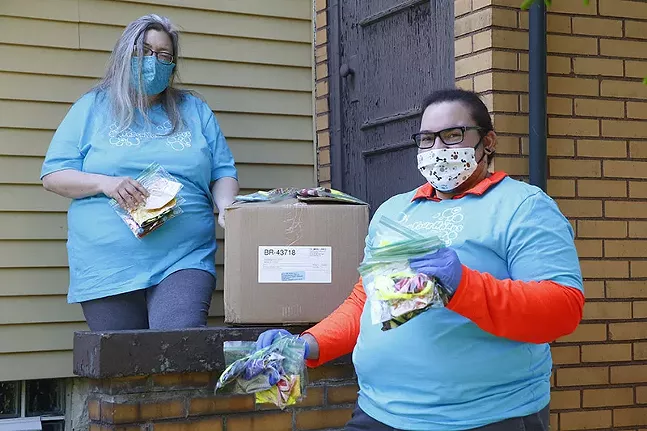 Sue Kerr, of Pittsburgh Lesbian Correspondents, and Allison Butka, of Etna Print Circus, pose for a portrait with masks they are donating to the LGBTQ community on Wed., May 13 in Etna, Pa. - CP PHOTO: JARED WICKERHAM