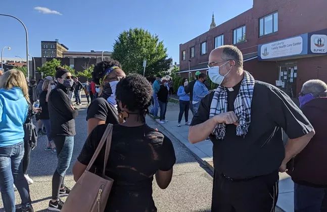 Pastor Paul Roberts (right) of Eastminster Presbyterian Church bumps elbows with two worshipers on May 31, 2020. - CP PHOTO: AMANDA WALTZ