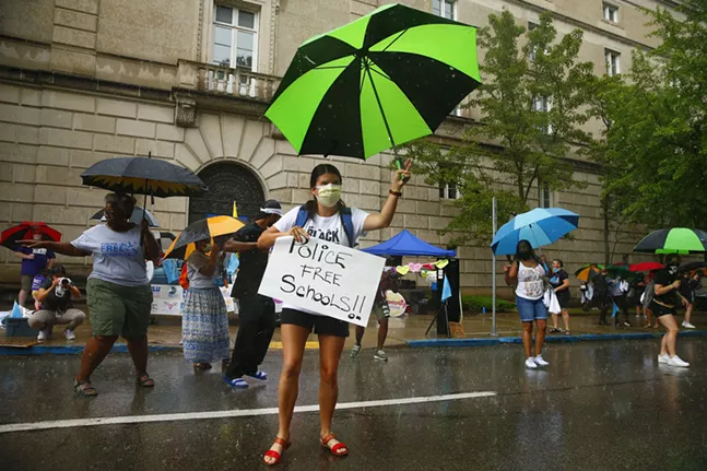 Protesters dance in the pouring rain as they demand police be removed from Pittsburgh Public Schools. - CP PHOTO: JARED WICKERHAM