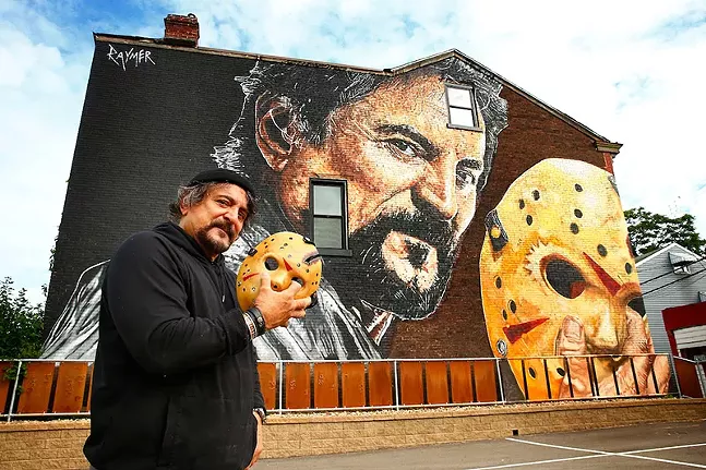 Tom Savini poses in front of the mural Pittsburgh artist Jeremy Raymer painted of his likeness in honor of his work on Friday the 13th movies - CP PHOTO: JARED WICKERHAM