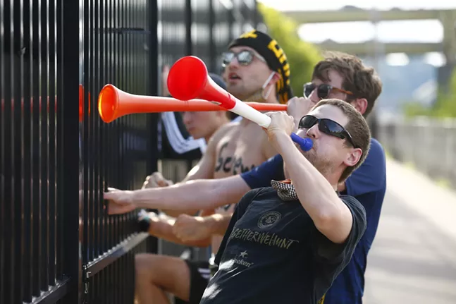 Stan Perko, Jack Powell, and Colin Funkhauser cheer on the Riverhounds from outside the fence along the Three Rivers Heritage Trail. - CP PHOTO: JARED WICKERHAM