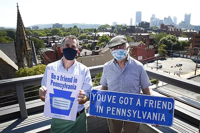 Larkin and Ray Werner pose with the #MaskUpPA poster — and its inspiration, on the North Side. - CP PHOTO: JARED WICKERHAM