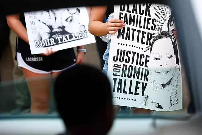 The son of Romir Talley looks out of a car and at signs carried by protesters at a rally for his father in Wilkinsburg on Sat., Aug. 22, 2020. - CP PHOTO: JARED WICKERHAM