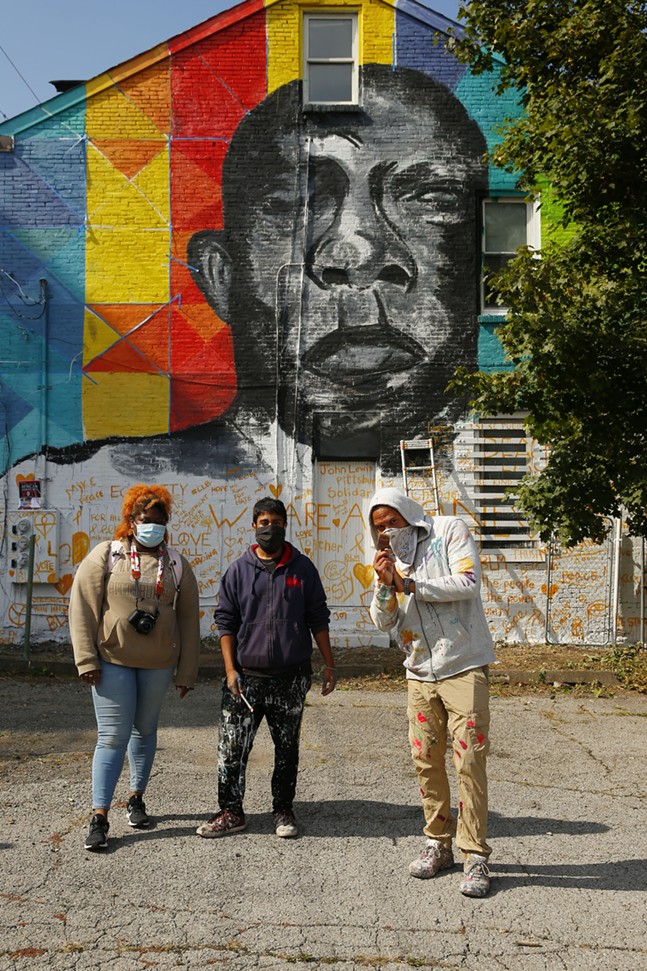 Adrie Rose, program assistant for Carlow University Social Justice Institutes, Zim Syed, lead artist, and Kyle Holbrook, executive artist with MLK Mural Project, pose for a portrait in front of the John Lewis mural in Uptown. - CP PHOTO: JARED WICKERHAM